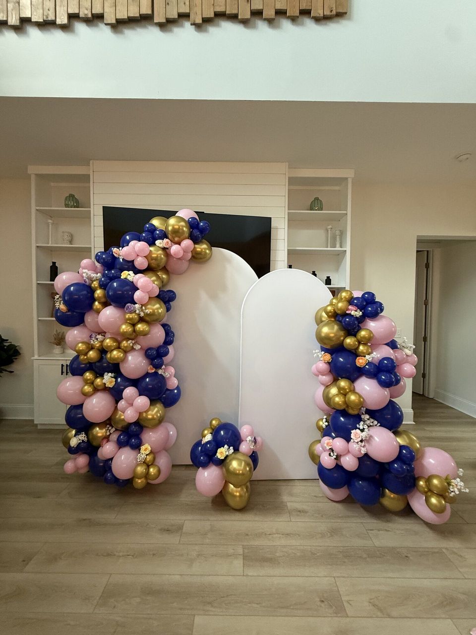 Navy, pink and gold balloon arch in a living room