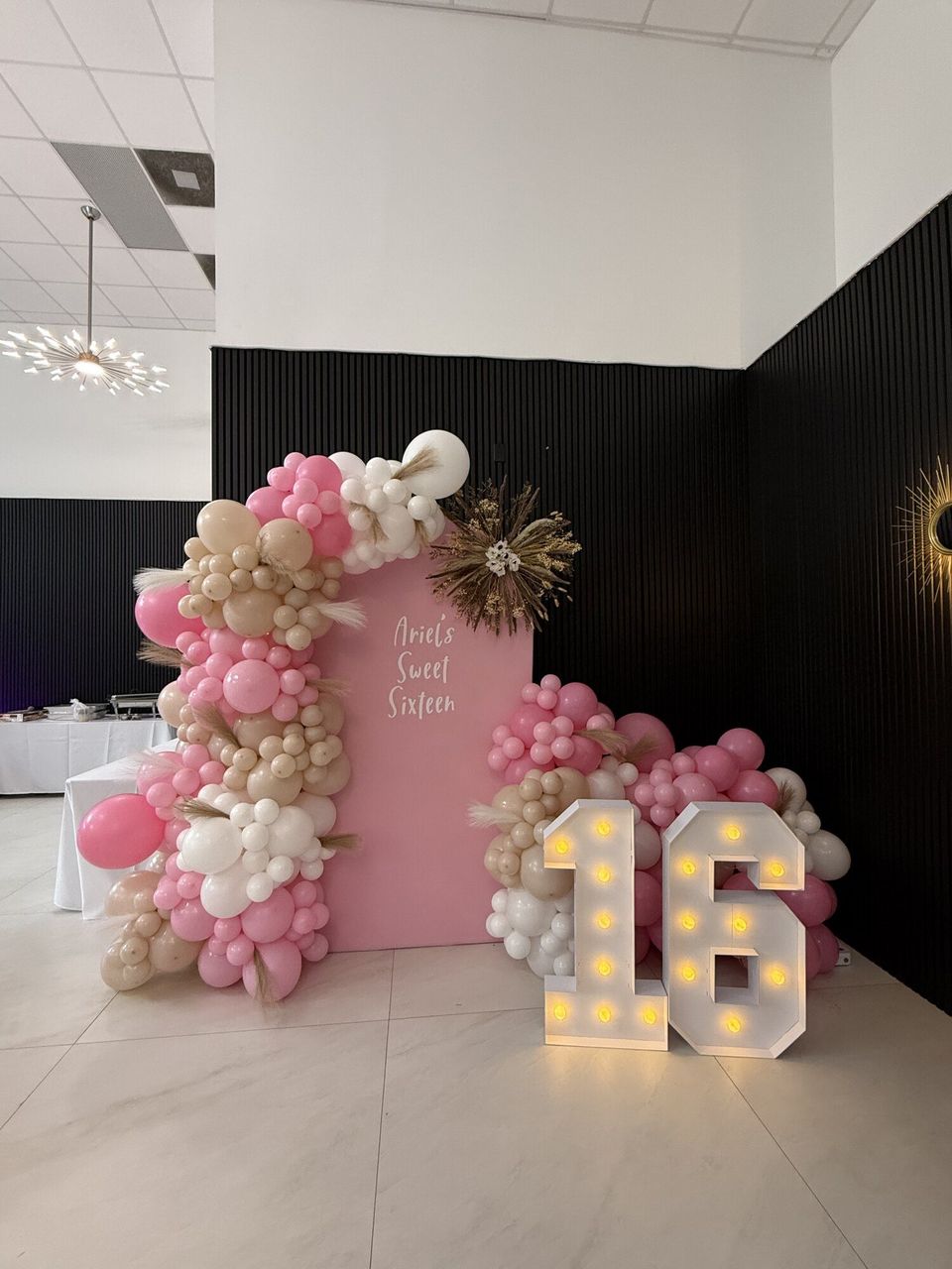 Balloon garland with a light-up number 16 at a birthday party